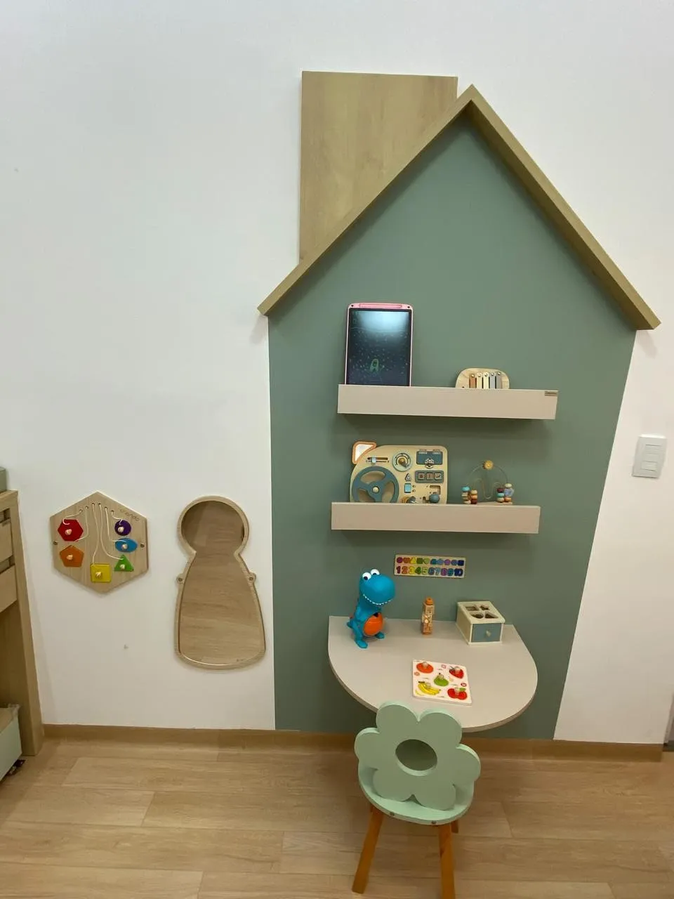 Cantinho de brincar do consultório: parede em forma de casinha com brinquedos educativos